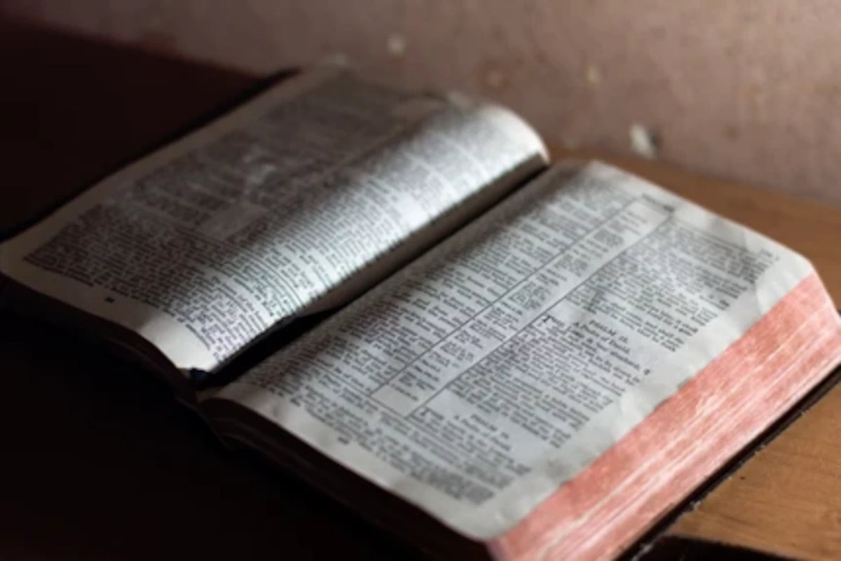 An open Bible resting on a wooden surface.